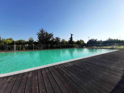 a large swimming pool on a wooden deck at Bilocale in residence con piscine in Numana