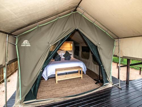 Tienda verde con cama en Langa Langa Tented Safari Camp, en Huntingdon
