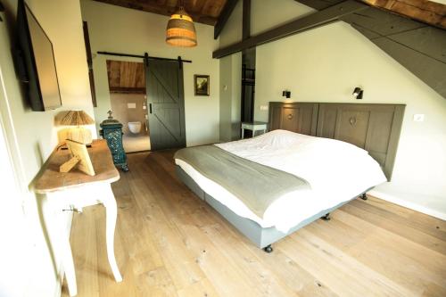 a bedroom with a bed and a wooden floor at Hof van Kleeberg in Mechelen