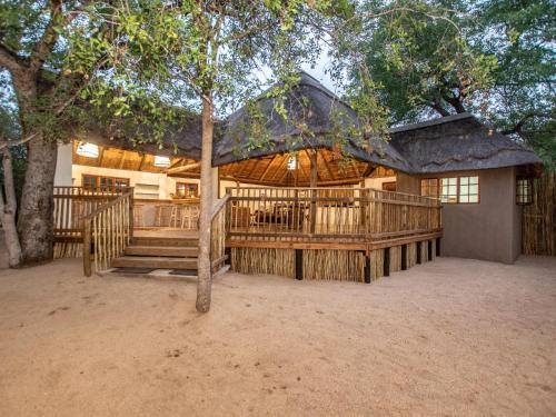 una grande casa in legno con un ampio ponte di Langa Langa Safari Camp - Inc 2 Kruger Safaris Daily a Riserva di Sabi Sand