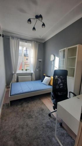 - une chambre avec un lit, un bureau et une chaise dans l'établissement Urban Nest Apartments Szewska 21-5, à Cracovie