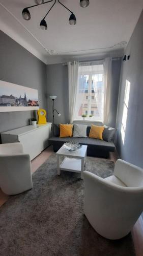 - un salon avec un canapé, des chaises et une table dans l'établissement Urban Nest Apartments Szewska 21-5, à Cracovie