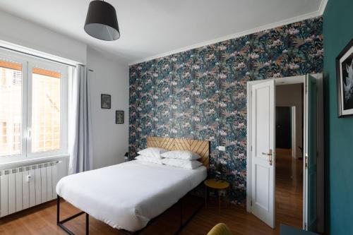 una camera da letto con un letto e carta da parati floreale di Domus Vaticana a Roma