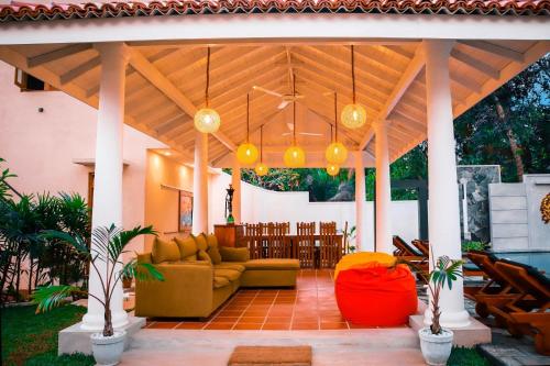 a patio with a couch and chairs under a pavilion at Tree of Life Resort in Bentota