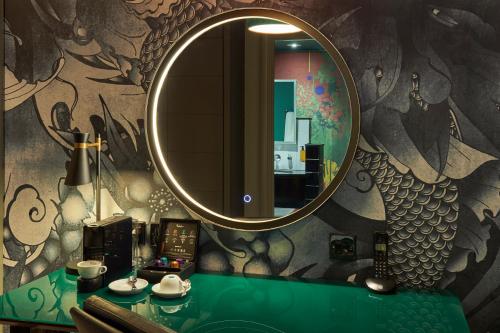 a bathroom with a mirror and a green counter with a sink at Malmaison Manchester in Manchester