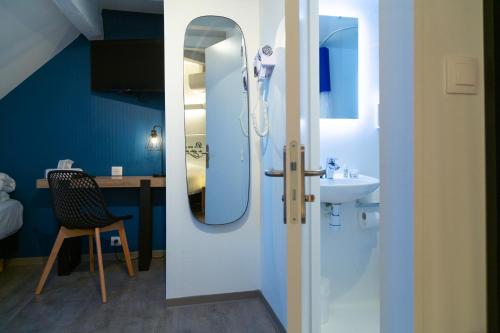 a bathroom with a sink and a mirror at Hotel Victoria in Strasbourg