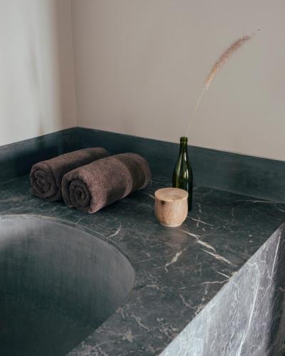 a bathroom with two towels and a bottle of wine at Riad no37 in Marrakech