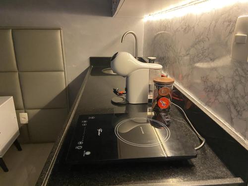 Loft em prédio sofisticado في ريو دي جانيرو: مطبخ مع حوض مع آلة صنع القهوة عليه