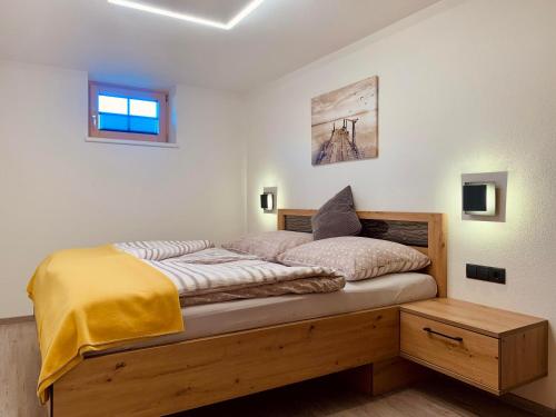 a bedroom with a bed with a yellow blanket on it at Apartment Silberwald in Steinberg am Rofan