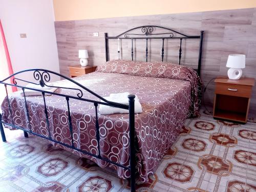 a bedroom with a bed and two night stands at Baffos House in Marsala