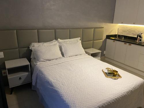 1 dormitorio con 1 cama grande con sábanas blancas en Loft em prédio sofisticado, en Río de Janeiro
