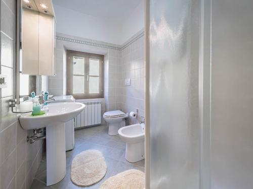 Baño blanco con lavabo y aseo en Alpi Apuane Panoramic Apartment, en Carrodano Inferiore