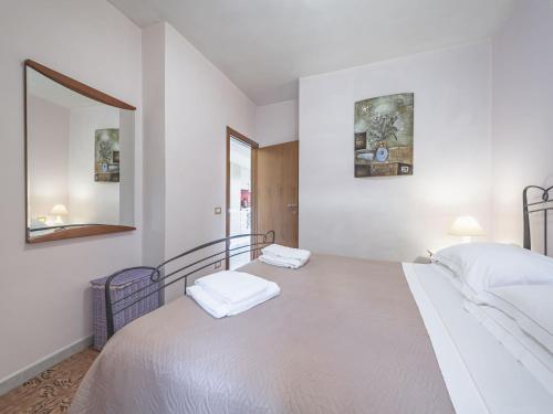 Habitación blanca con 2 camas y espejo. en Alpi Apuane Panoramic Apartment, en Carrodano Inferiore