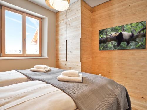a bedroom with two beds and a painting of an animal at Mountain Lover one by AA Holiday Homes in Tauplitz