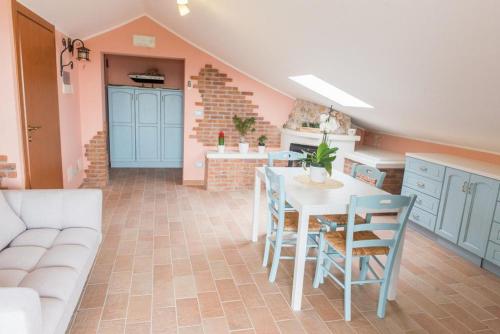 a kitchen with a table and chairs and a couch at Vista Allegra Pagoda - Villa con piscina in Colonnella