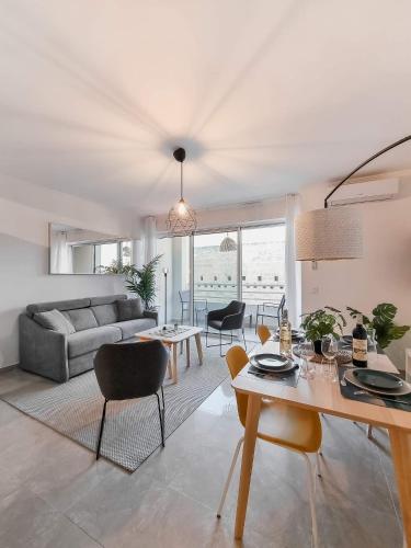 un salon avec un canapé, une table et des chaises dans l'établissement LE SOLEIL Résidence la Fontaine Les Sablettes Plage, à La Seyne-sur-Mer