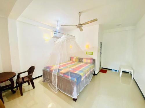 una camera da letto con un letto con zanzariera di Inu Vicky Beach Hotel a Tangalle