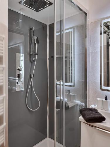 une douche avec une porte vitrée dans une salle de bain dans l'établissement LE SOLEIL Résidence la Fontaine Les Sablettes Plage, à La Seyne-sur-Mer