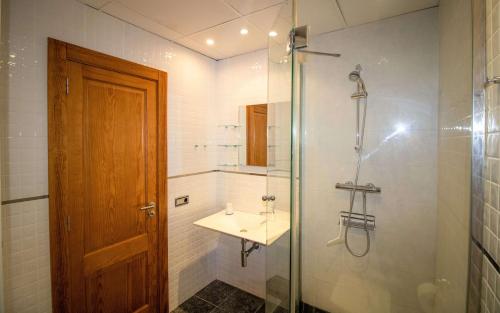baño con lavabo y ducha con puerta de cristal en Luxury Penthouse Alcossebre Beach Resort - ALBERT VILLAS en Alcocéber