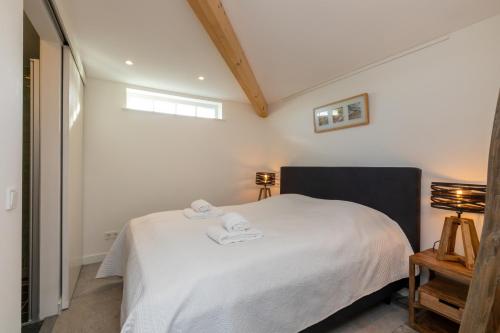 a bedroom with a white bed with two towels on it at Vakantiehuis Noordweg 4a, Oostkapelle in Oostkapelle