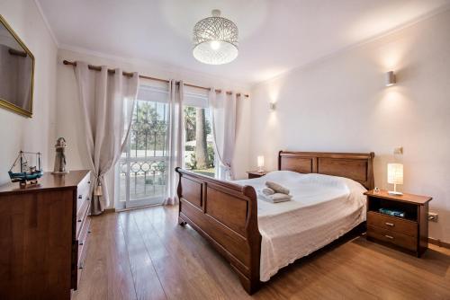 a bedroom with a bed and a large window at Celina by Algarve Villa Holidays in Guia