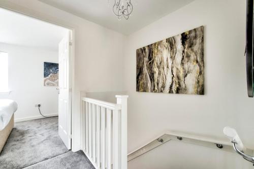 une chambre blanche avec un escalier et un tableau sur le mur dans l'établissement 2-Bedroom Holiday Home With Private Garden & Parking, à Édimbourg