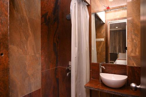 y baño con lavabo y espejo. en HOTEL CENTER POINT en Solāpur