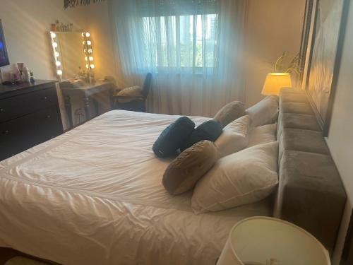 a large white bed with pillows and a couch at Room Riverside Parque das Nações in Lisbon