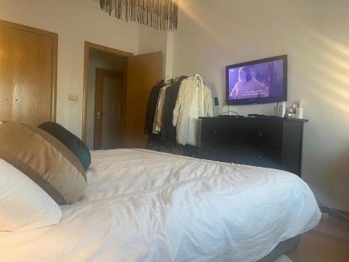 a bedroom with a bed and a tv on a wall at Room Riverside Parque das Nações in Lisbon