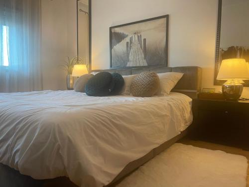 a bedroom with a white bed with two pillows at Room Riverside Parque das Nações in Lisbon