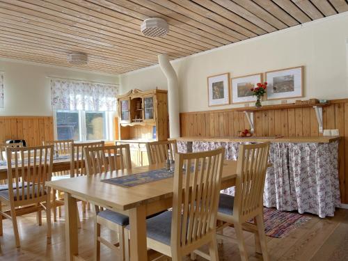 a dining room with a wooden table and chairs at Fulufjällsgården in Mörkret