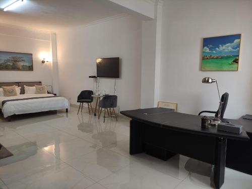 Cette chambre d'hôtel dispose d'un bureau et d'un lit. dans l'établissement Feima Hotel, à Antananarivo