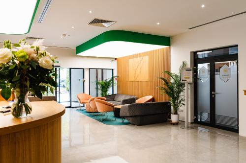 a lobby with couches and chairs in a building at Hotel Küküllő - Târnava in Odorheiu Secuiesc