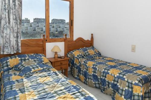 1 dormitorio con 2 camas y ventana en Villas Cap Blanc, 1-31 Cab I-36, en Cullera