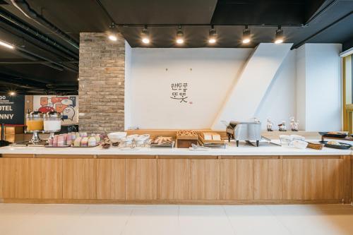 a restaurant with a counter with chairs and tables at Kenny Stay Jeju Seogwipo in Seogwipo