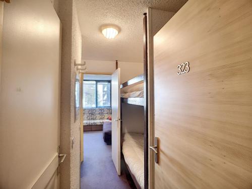 Cette petite chambre comprend des lits superposés et une porte. dans l'établissement Studio 4 pers, skis aux pieds, cuisine équipée - FR-1-178-321, aux Menuires