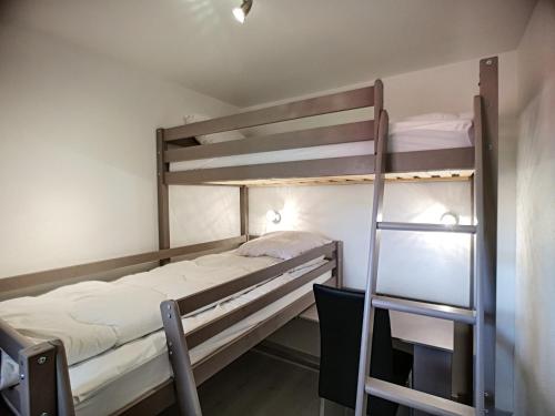 une chambre avec deux lits superposés et une échelle dans l'établissement Charmant 3 Pièces Rénové, Ski aux Pieds, Balcon Sud, 6 Pers. – Les Bruyères, Rés. Valmonts, 3 Flocons Or - FR-1-178-322, aux Menuires
