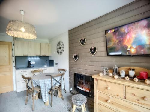 Il comprend une cuisine avec une table et une télévision murale. dans l'établissement 2 pièces rénové 30m², sud, Les Bruyères, Les Menuires - 4 pers, pistes, 3 Flocons Or - FR-1-178-320, aux Menuires
