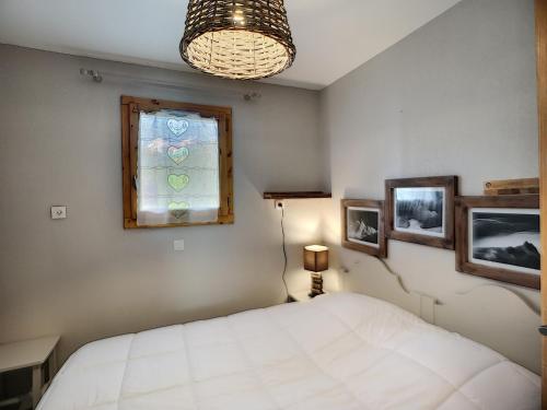 une chambre avec un lit blanc et une fenêtre dans l'établissement 2 pièces rénové 30m², sud, Les Bruyères, Les Menuires - 4 pers, pistes, 3 Flocons Or - FR-1-178-320, aux Menuires