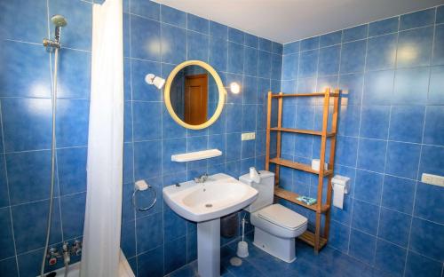 a blue tiled bathroom with a sink and a toilet at Adosado con piscina a 50 metros de la playa - Las Fuentes ALBERT VILLAS in Alcossebre