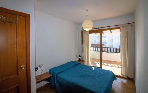 a bedroom with a blue bed and a balcony at Adosado con piscina a 50 metros de la playa - Las Fuentes ALBERT VILLAS in Alcossebre