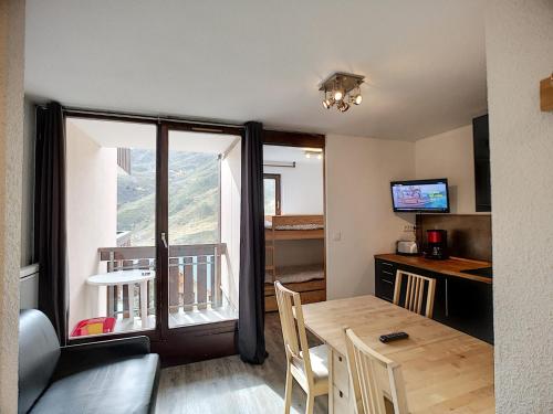 Cette petite chambre dispose d'une table et d'un balcon. dans l'établissement Joli 2P pour 4, au pied des pistes, quartier Bruyères, Les Menuires - FR-1-178-332, aux Menuires