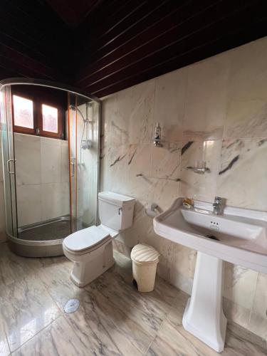 a bathroom with a sink and a toilet and a shower at A 1 minuto do Mar! Casa Mármore V4 em Zona Sossegada na Ilha do Mussulo in Belas