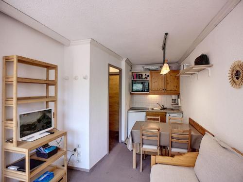 Il comprend un salon et une cuisine avec une table et des chaises. dans l'établissement Joli 2 pièces 25m² skis aux pieds, balcon exposé sud, 4 pers - FR-1-178-342, aux Menuires