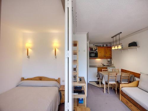 Cette petite chambre comprend un lit et une salle à manger. dans l'établissement Joli 2 pièces 25m² skis aux pieds, balcon exposé sud, 4 pers - FR-1-178-342, aux Menuires