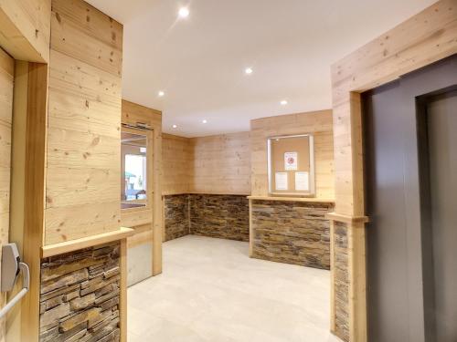 Cette chambre est dotée de lambris et d'un mur en pierre. dans l'établissement Studio 4 pers, pied des pistes - Résidence Carlines I, Les Menuires, quartier animé des Bruyères - FR-1-178-346, aux Menuires