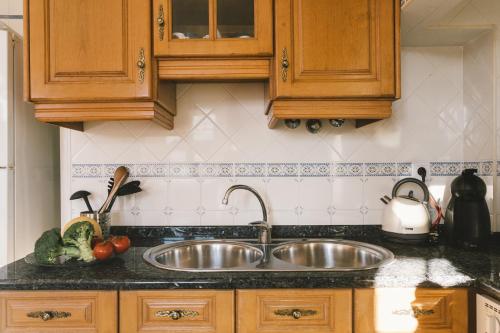 - une cuisine avec un évier en acier inoxydable et des placards en bois dans l'établissement Best Houses 56 - Charming House in Peniche, à Peniche