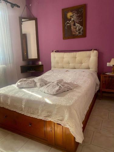 1 dormitorio con 1 cama con espejo en la pared en Διαμέρισμα Αγγελική, en Makrinitsa