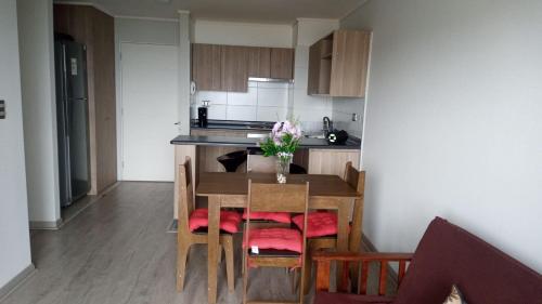 a kitchen with a table and chairs and a kitchen with at Depto. con vista al mar 4° piso, Tomé, Dichato in Tomé
