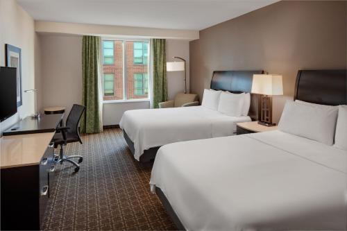 a hotel room with two beds and a desk at The Limited Hotel in Charleston